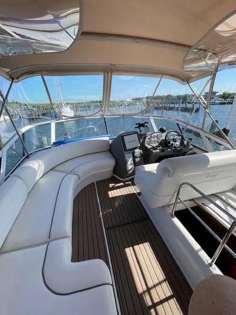 Slide: The Image of 2006 Cruisers Yachts 385 Motoryacht interior helm with white seating and wood flooring. - 19
