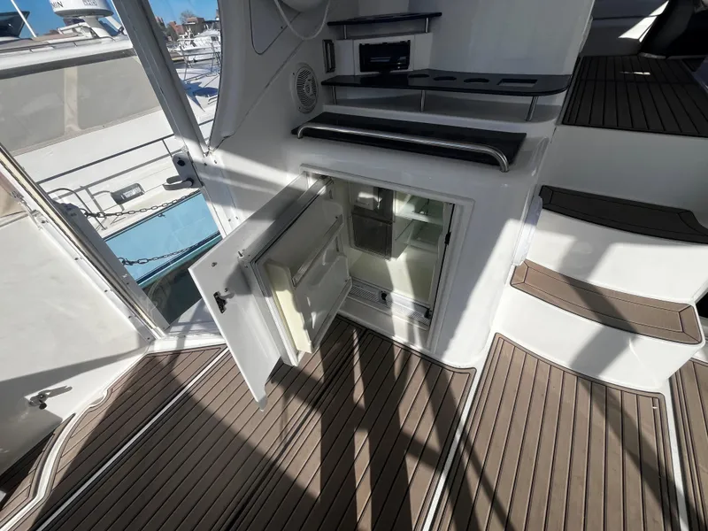 Slide: The Image of 2006 Cruisers Yachts 385 Motoryacht interior with open refrigerator and wooden flooring. - 21