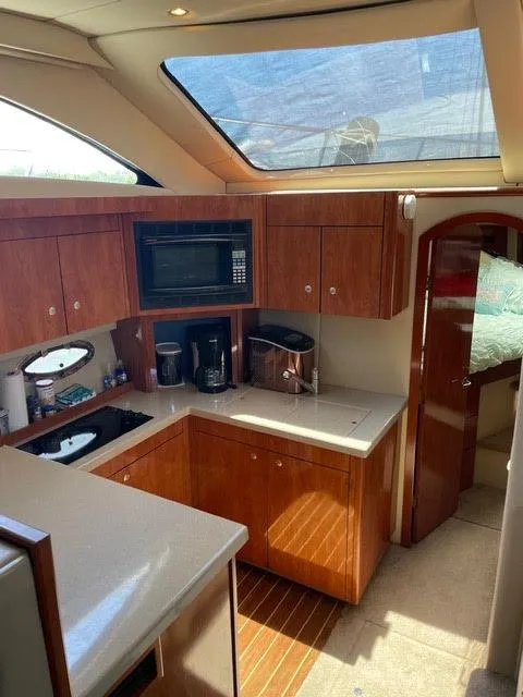 Slide: The Image of 2006 Cruisers Yachts 385 Motoryacht kitchen with wood cabinetry, microwave, and skylight. - 7