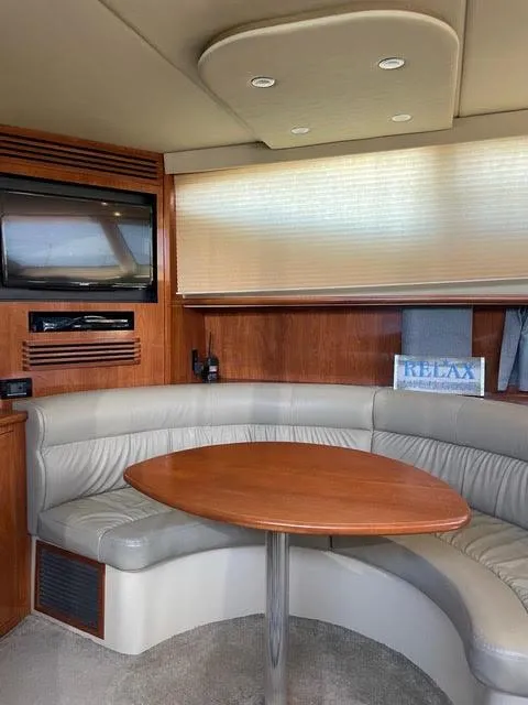 Slide: The Image of Interior of 2006 Cruisers Yachts 385 Motoryacht with curved seating and wooden table. - 8