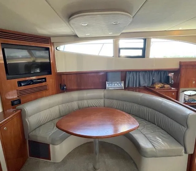 Slide: The Image of Interior of 2006 Cruisers Yachts 385 Motoryacht with curved seating and wooden table. - 9