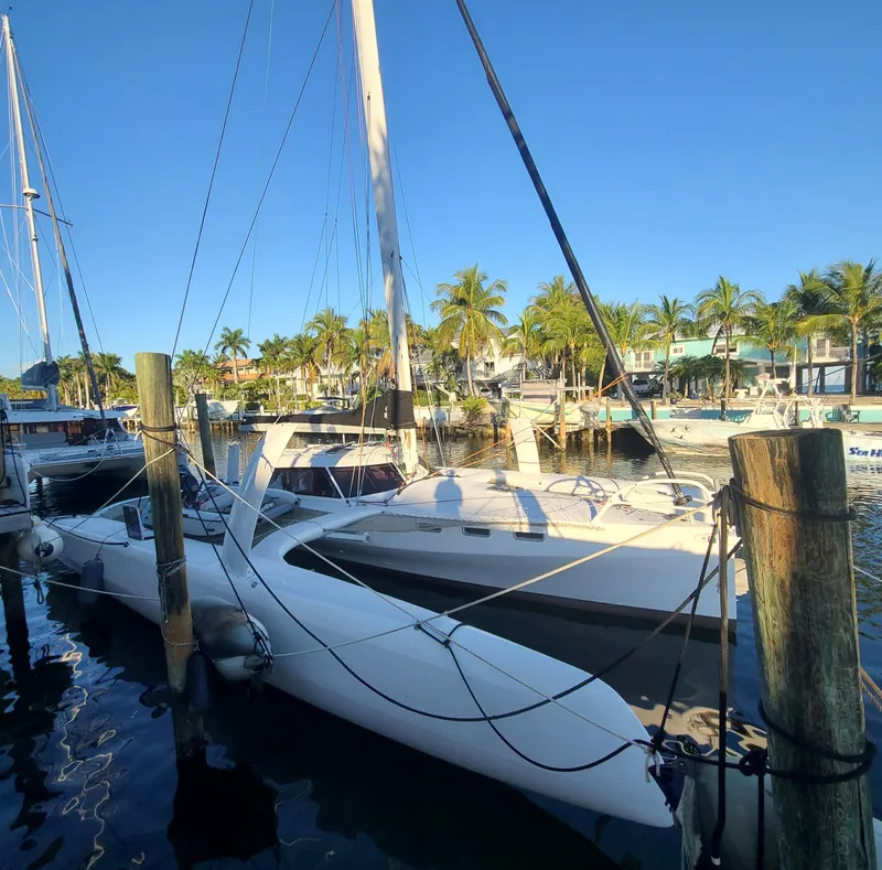 Slide: The Image of 2025 Rapido 40 trimaran docked at a marina with palm trees in the background. - 1