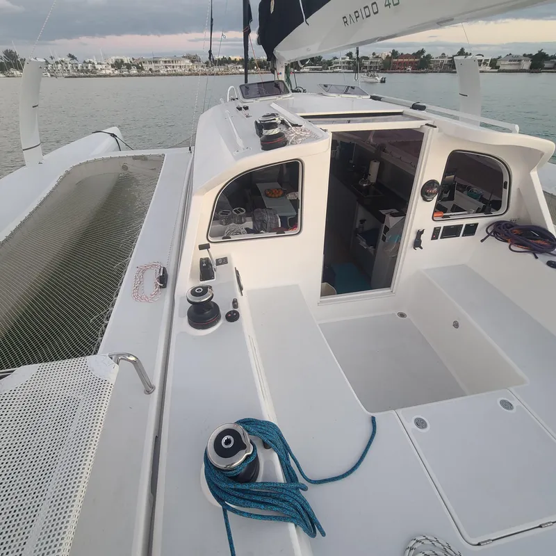 Slide: The Image of 2025 Rapido 40 sailboat deck with open cabin, moored by the shore. - 3