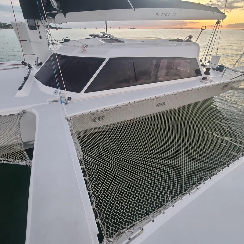 Slide: The Image of 2025 Rapido 40 catamaran with netting, docked at sunset. - 4