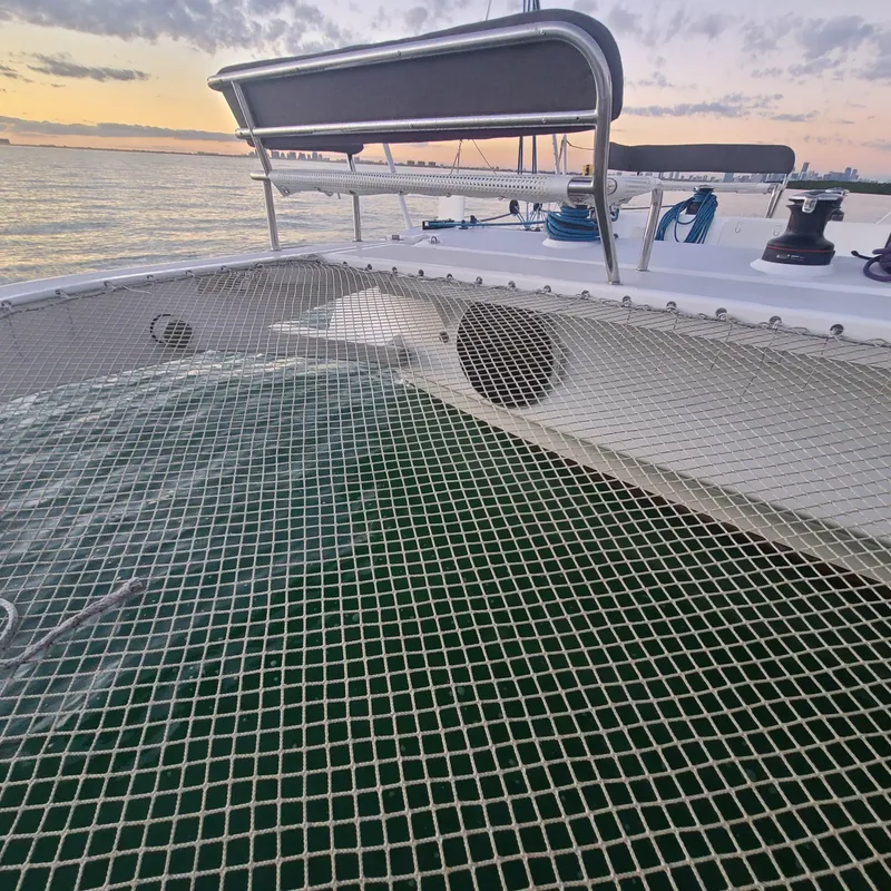 Slide: The Image of 2025 Rapido 40 catamaran deck with netting, ocean view at sunset. - 7