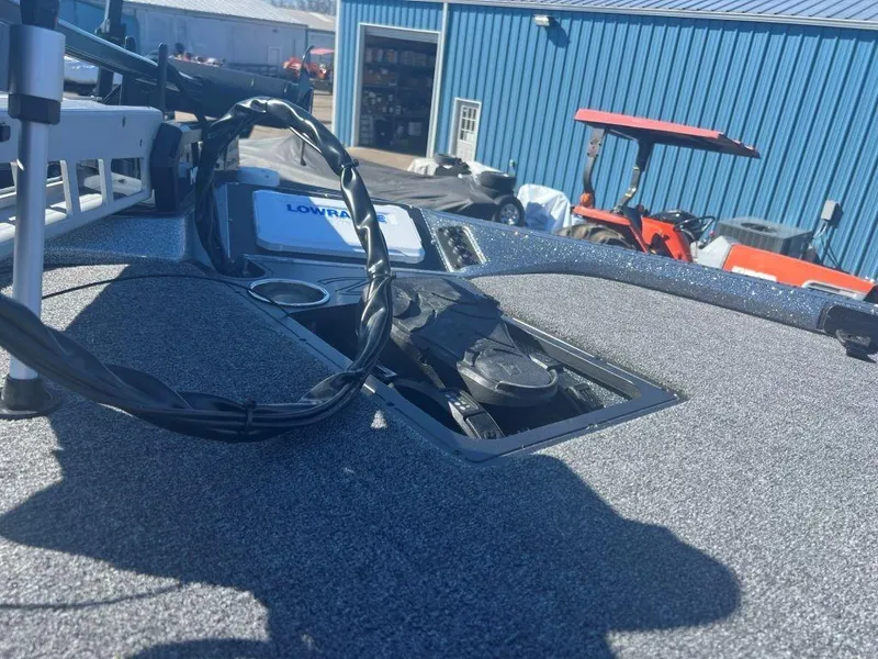 Slide: The Image of 2023 Ranger Z518 boat deck with equipment, blue building and red vehicle in background. - 7