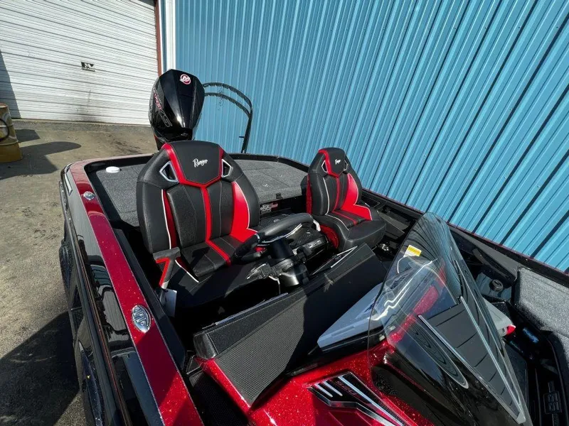 Slide: The Image of 2023 Ranger Z520R Ranger Cup Equipped boat with red and black seats, docked near a blue building. - 14