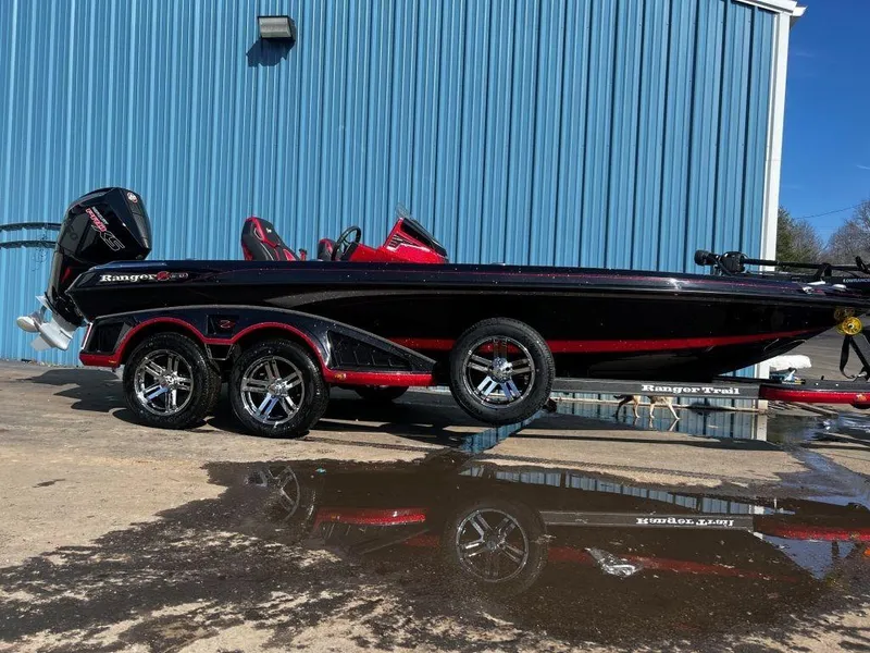 Slide: The Image of 2023 Ranger Z520R Ranger Cup Equipped boat, black and red, parked outside a blue building. - 2