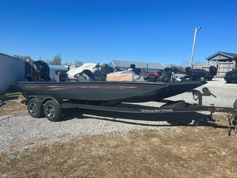 The Image of 2023 Ranger RT198P fishing boat on a trailer in a gravel lot. - 1