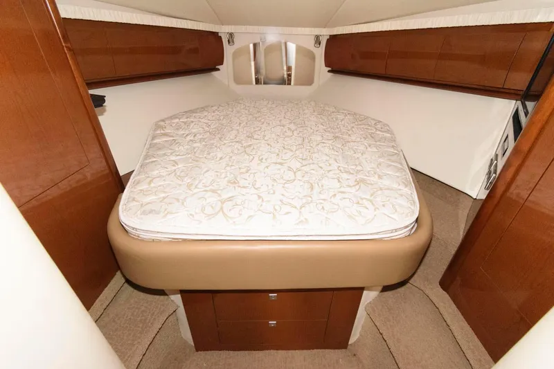 Slide: The Image of 2008 Sea Ray 44 Sundancer cabin with bed, wooden cabinets, and beige carpet. - 19