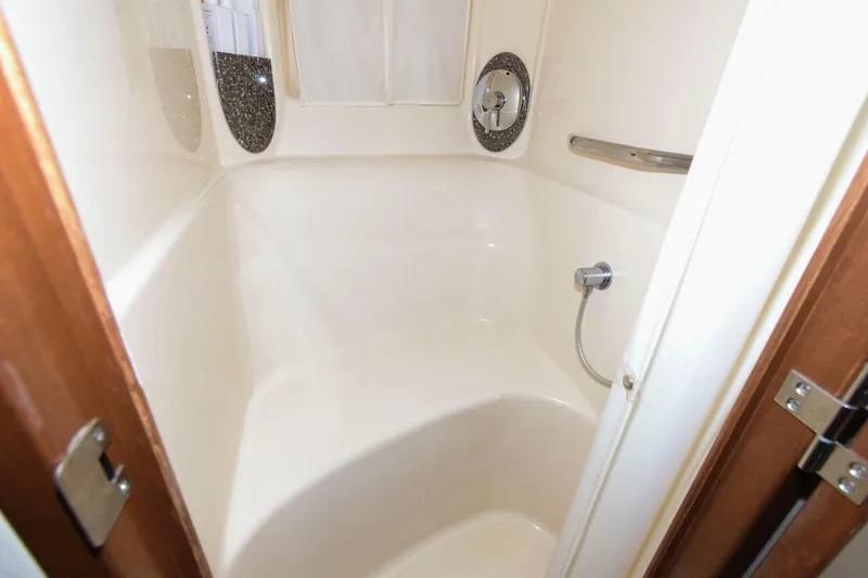Slide: The Image of 2008 Sea Ray 44 Sundancer bathroom with shower, white interior, and chrome fixtures. - 21
