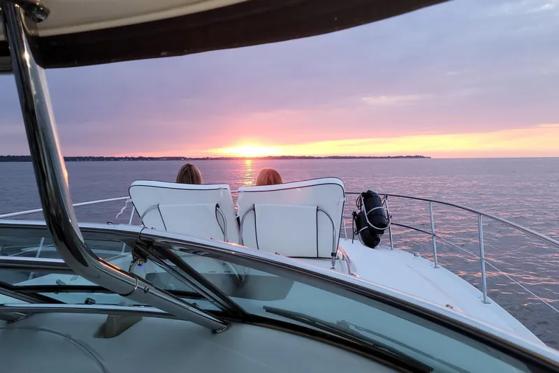 Slide: The Image of 2008 Sea Ray 44 Sundancer yacht at sunset, two people relaxing on deck chairs. - 6