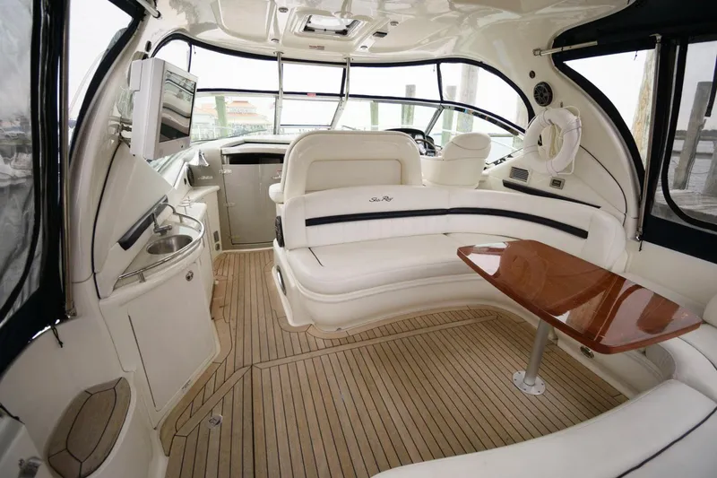 Slide: The Image of Interior of 2008 Sea Ray 44 Sundancer yacht with white seating and wooden table. - 7