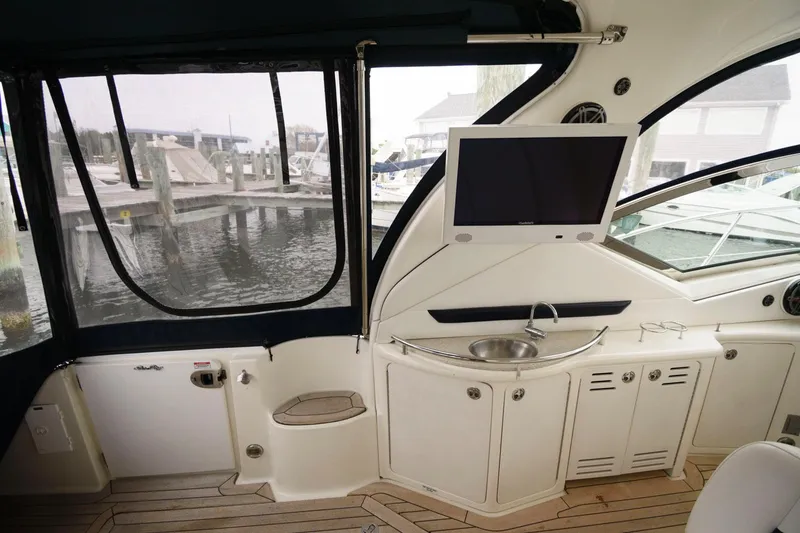 Slide: The Image of Interior of 2008 Sea Ray 44 Sundancer yacht with TV, sink, and marina view. - 9