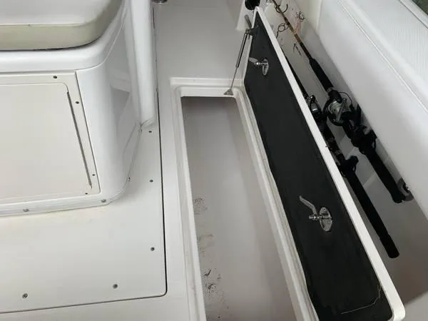 Slide: The Image of 2016 Robalo R300 Center Console boat interior with storage compartment and fishing rod holders. - 11