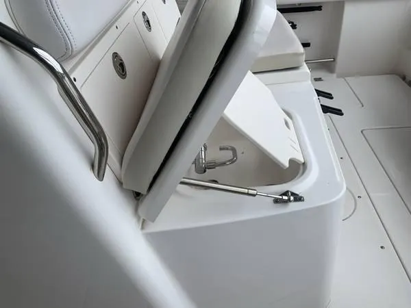 Slide: The Image of 2016 Robalo R300 Center Console boat seat with storage compartment open. - 16