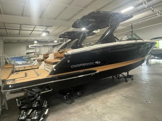 Slide: The Image of 2024 Chaparral 287 SSX boat in showroom, black exterior with tan interior. - 2