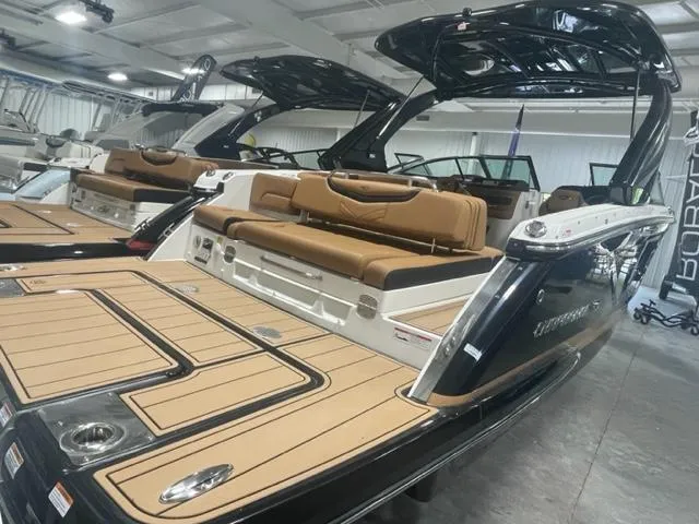 Slide: The Image of 2024 Chaparral 287 SSX boat with tan seating and black exterior in showroom. - 4