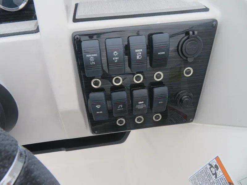 Slide: The Image of Control panel of 2023 Starcraft SVX 211 OB boat with various switches and outlets. - 7
