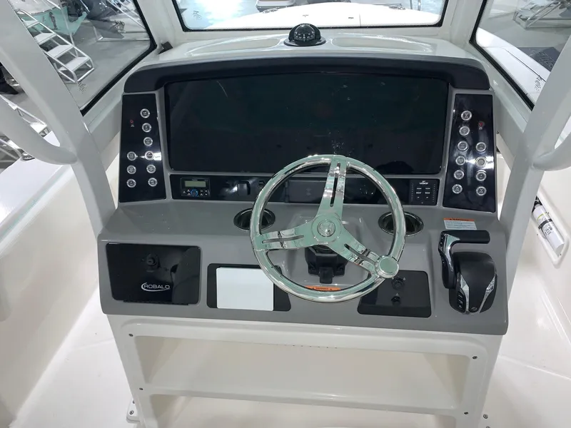 Slide: The Image of 2024 Robalo 266 Cayman boat helm with steering wheel and control panel. - 13
