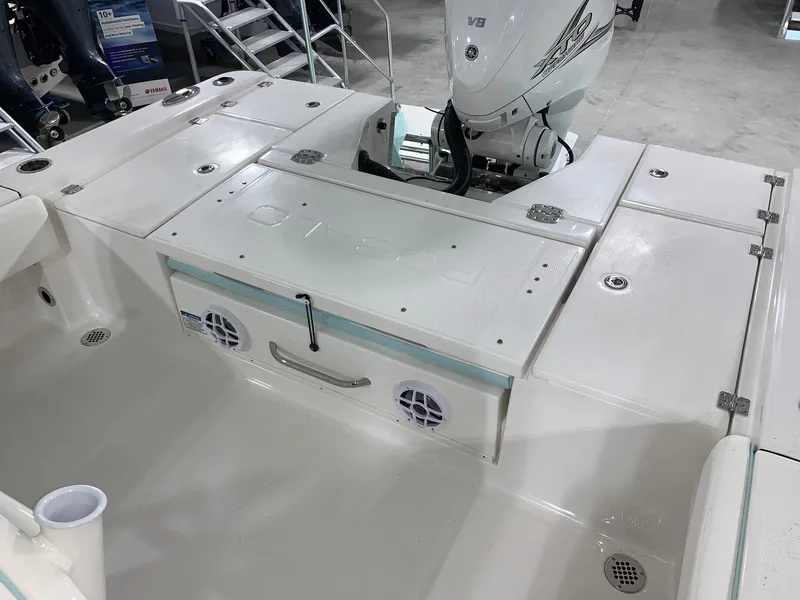 Slide: The Image of 2024 Robalo 266 Cayman boat deck with storage compartments and outboard motor. - 15