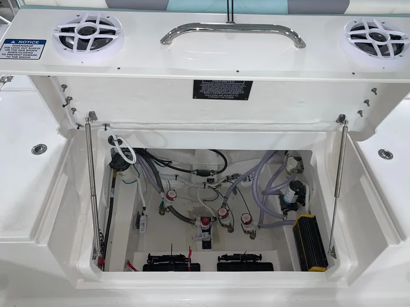 Slide: The Image of 2024 Robalo 266 Cayman boat storage compartment with wiring and battery setup. - 20