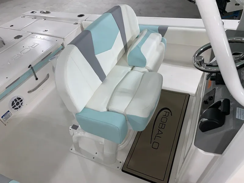 Slide: The Image of 2024 Robalo 266 Cayman boat interior with cushioned seating and steering console. - 12