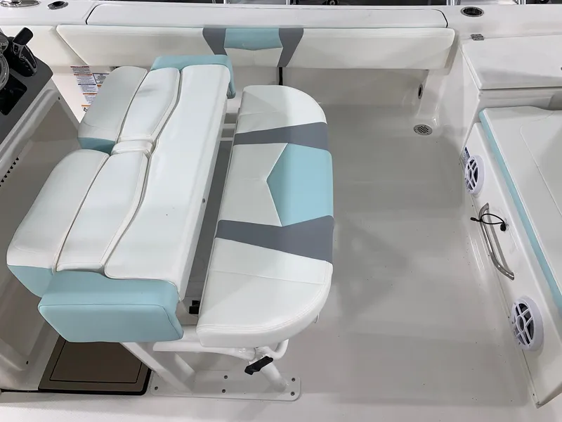 Slide: The Image of 2024 Robalo 266 Cayman boat interior seating with white, blue, and gray upholstery. - 16
