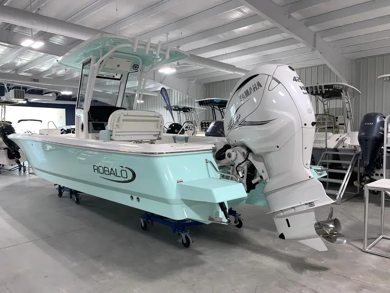 Slide: The Image of 2024 Robalo 266 Cayman boat with Yamaha outboard motor in showroom. - 2