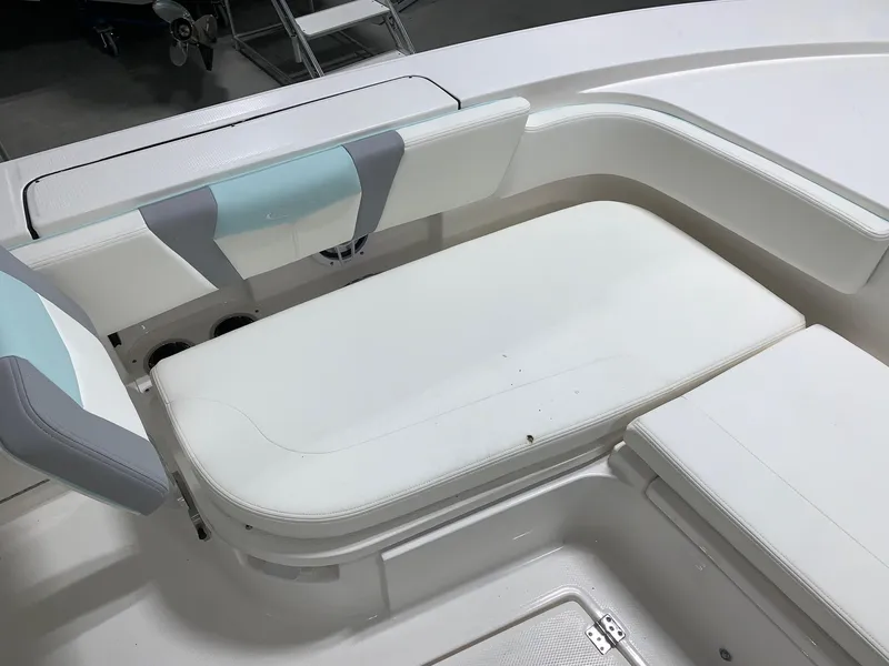 Slide: The Image of 2024 Robalo 266 Cayman boat interior seating area with white and gray cushions. - 6