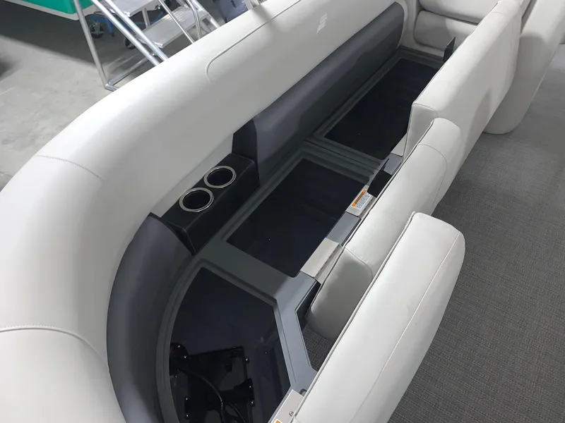 Slide: The Image of 2024 Starcraft LX22 R pontoon boat interior with storage compartments and cup holders. - 11