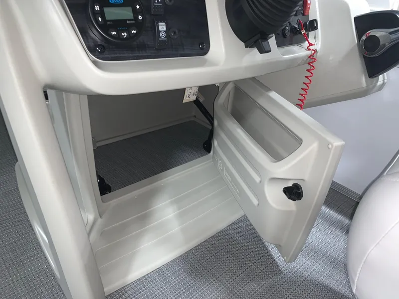 Slide: The Image of 2024 Starcraft LX22 R boat console storage compartment with open door. - 12