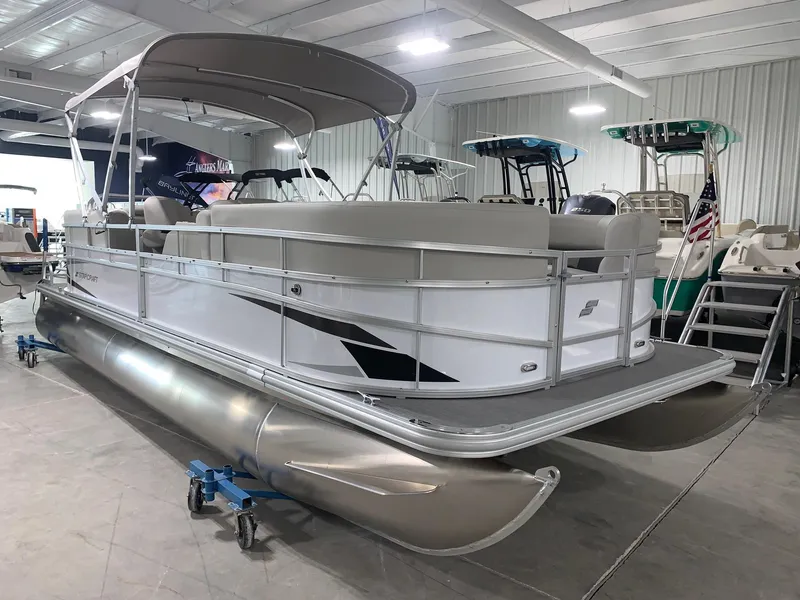 Slide: The Image of 2024 Starcraft LX22 R pontoon boat in showroom. - 2