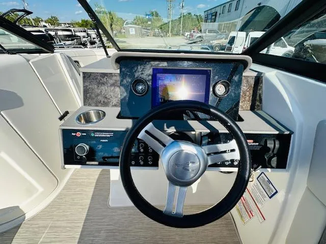 Slide: The Image of 2021 Sea Ray 270 SDX boat dashboard with steering wheel and navigation screen. - 20