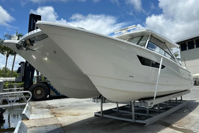 Slide: The Image of 2021 World Cat 400 DC-X boat on a lift at a marina. - 1