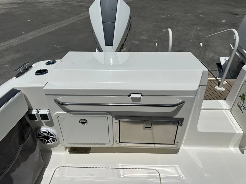 Slide: The Image of 2021 World Cat 400 DC-X boat deck with storage compartments and speaker. - 13