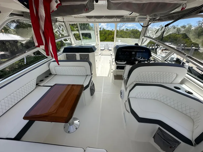 Slide: The Image of Interior of 2021 World Cat 400 DC-X boat with white seating and wooden table. - 22