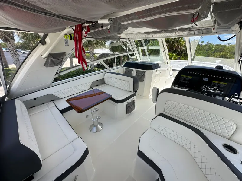 Slide: The Image of Interior of 2021 World Cat 400 DC-X boat with white seating and wooden table. - 24