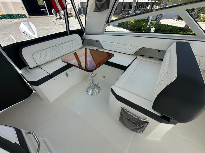 Slide: The Image of Luxurious seating area inside 2021 World Cat 400 DC-X boat with a wooden table. - 25
