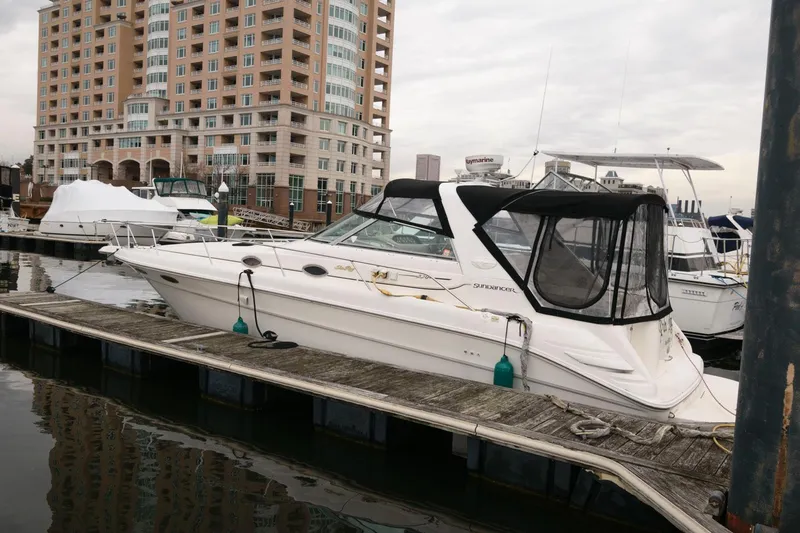 Slide: The Image of 1998 Sea Ray 330 Sundancer docked at marina with cityscape background. - 1
