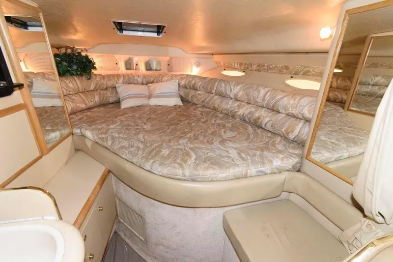 Slide: The Image of Interior cabin of 1998 Sea Ray 330 Sundancer with plush bedding and mirrors. - 12