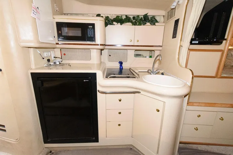 Slide: The Image of 1998 Sea Ray 330 Sundancer galley with sink, microwave, and fridge. - 13