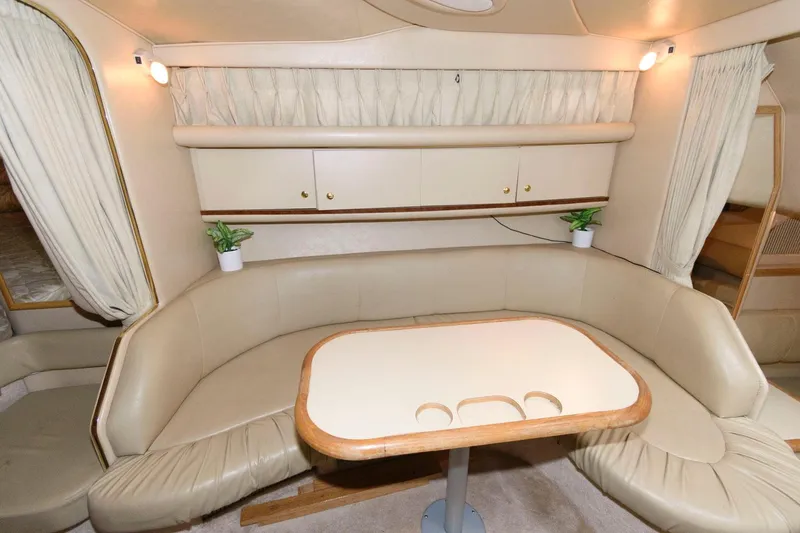 Slide: The Image of Interior of 1998 Sea Ray 330 Sundancer with beige seating and table. - 14