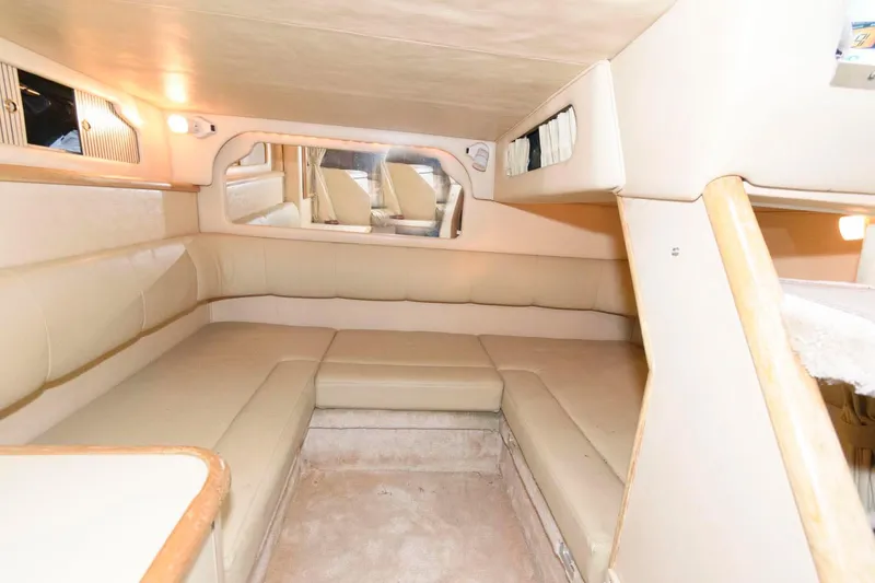 Slide: The Image of Interior of 1998 Sea Ray 330 Sundancer, featuring beige seating and wood accents. - 15