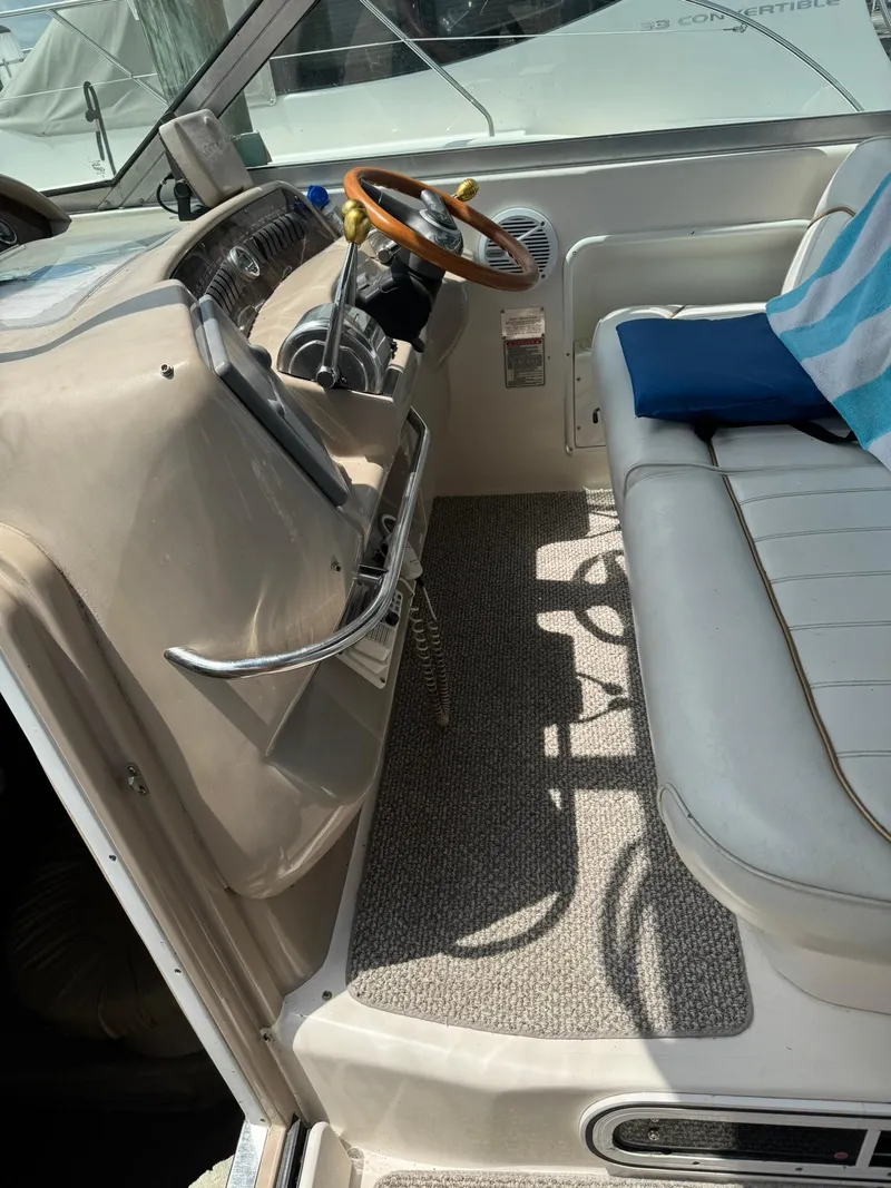 Slide: The Image of 1998 Sea Ray 330 Sundancer cockpit with steering wheel and seating area. - 6