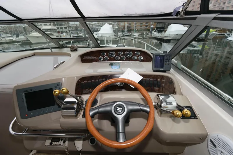 Slide: The Image of 1998 Sea Ray 330 Sundancer helm with steering wheel and navigation controls. - 7