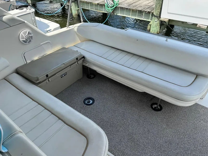 Slide: The Image of 1998 Sea Ray 330 Sundancer boat interior with cushioned seating and Yeti cooler. - 8