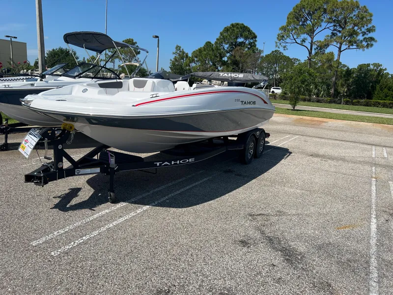 Slide: The Image of 2023 Tahoe 2150 boat on trailer in parking lot, sunny day. - 1