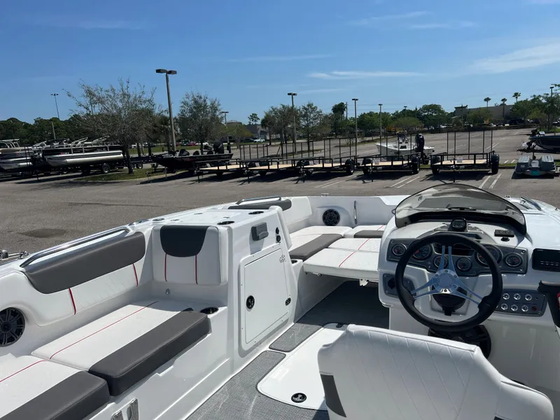 Slide: The Image of 2023 Tahoe 2150 boat interior with steering wheel and seating in a parking lot. - 5