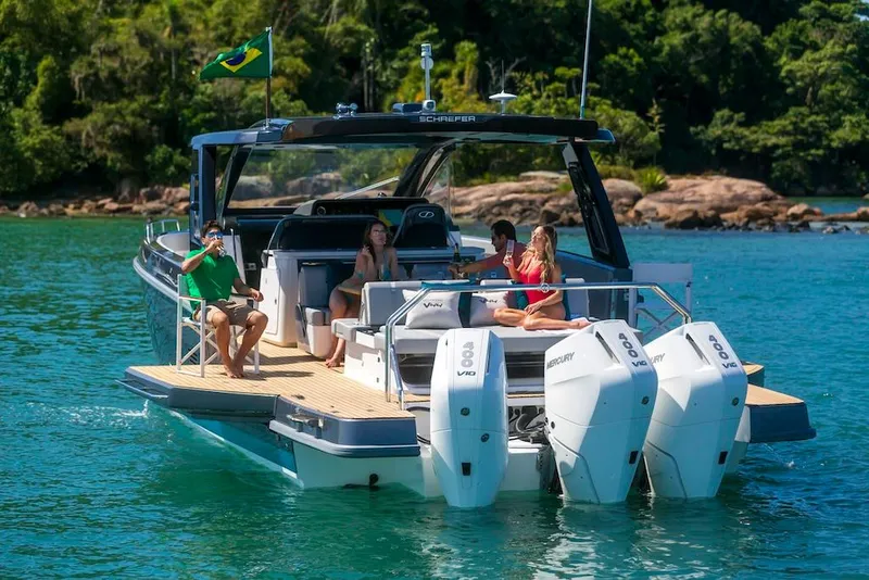 Slide: The Image of People relaxing on a 2025 Schaefer V44 boat with twin Mercury engines. - 11